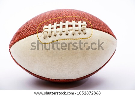 Brown rugby ball against a white backdrop.