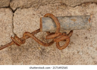 Brown Rusty Old Iron Wire On A Gray Metal Fastener In A Concrete Wall