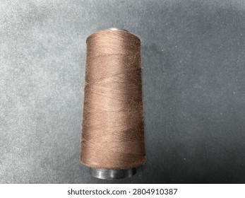 Brown sewing thread on dark background