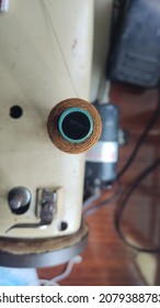 The Brown Sewing Thread Spool In The Sewing Machine Is Taken From Above