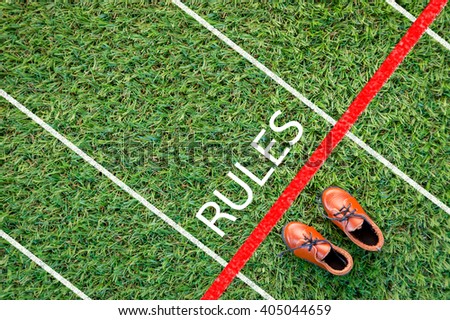 brown shoes standing on the grass field with the word rules  The concept of 'rules'