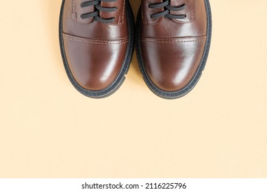 Brown Shoes. Trendy Boots Pair On Neutral Beige Background. Copy Space, Top View, Flat Lay. Shoe Sale, Fashion Concept. Stylish Casual Shoes For City. Overhead Shot Of Chelsea Boots. Urban Lifestyle.