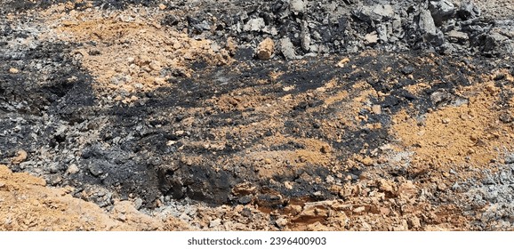 Brown soil intermixed with coal creates a distinctive landscape where the earthy hues of the soil contrast with the dark richness of coal deposits. - Shutterstock ID 2396400903