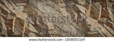 Brown stone background. Rock texture. Mountain surface. Close-up. Stone wall. Wide banner with  copy space for your design.