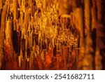 Brown stone mineral formations on the wall in Damlatas cave in Alanya Turkey, close-up. Natural abstract brown-orange background of stalactites and stalagmites. High quality photo