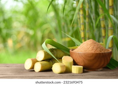 Brown sugar with fresh sugar cane on wooden table with sugar cane plantation farming background.