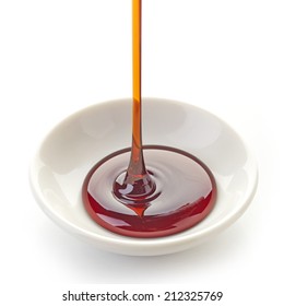 Brown Sugar Syrup Pouring Into Bowl Isolated On White