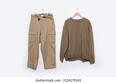 Brown Sweaters With Khaki Pants On Hanging On The White Background