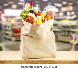 Brown Table And On Background Blured Supermarket And Bag With Products