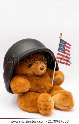 Brown teddy bear with an American flag and a military helmet on a white background, isolate.