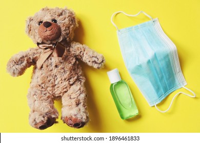 Brown Teddy Bear, Face Mask And Hand Sanitizer. Child Safety And Hygiene In The Coronavirus Epidemic. Protection Of Children During The COVID-19 Pandemic