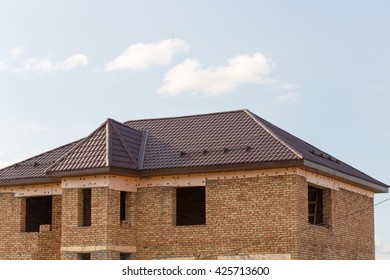 brown tiled roof on a new home with blue sky