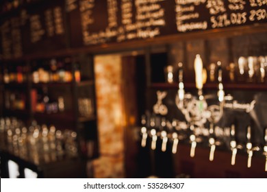 Brown Toned Bar Out Of Focus Blurred Background With Beer Cranes And Menu On Chalkboard