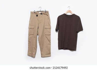 Brown T-shirt With Khaki Pants On Hanging On The White  Background