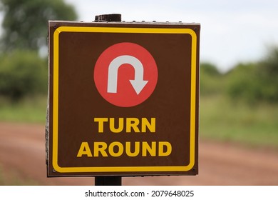 Brown Turn Around Road Sign With Blurred Background. Direction, Mistake, Road, Travel, Choice Concept.