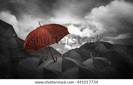brown umbrella in mass of black umbrellas