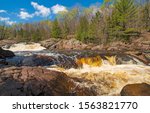 Brown Water flowing over a Red Granite Falls on the Bad River in Copper Falls State Park in Wisconsin