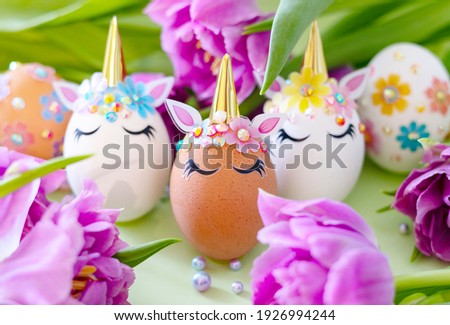 brown and white Easter eggs decorated in the form of unicorns on a green and yellow background with bouquet of tulips, a minimal creative concept of a happy Easter