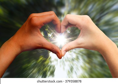 Brown And White Skin Hands In Heart Shape, Sunlight Coming Through.