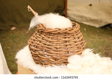 A Brown Wicker Basket Filled With Raw Sheep Wool.