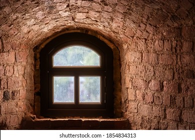 Brown window with an arch in a recess in the wall made of old red brick. From the window of the world series.