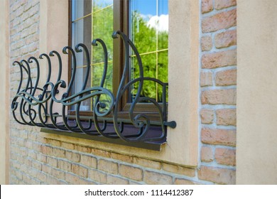 Brown window with stylized iron mesh