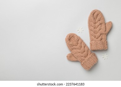 Brown winter mittens on color background. Top view
