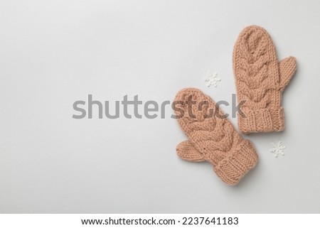 Brown winter mittens on color background. Top view