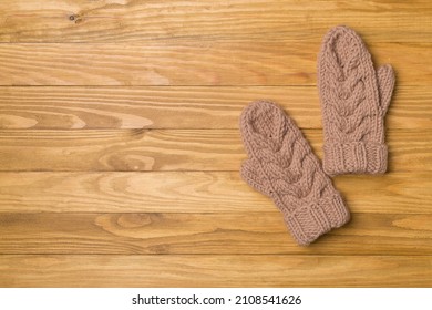 Brown Winter Mittens On Wooden Background. Top View.