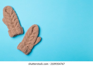 Brown Winter Mittens On Wooden Background. Top View.