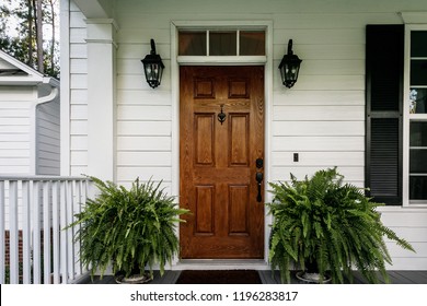 Brown Wood Front Door of a White Siding Southern House - Shutterstock ID 1196283817