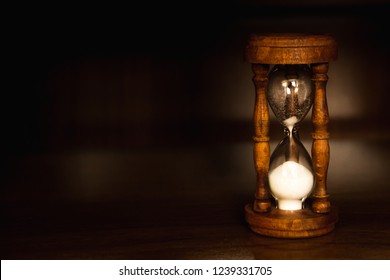 Brown wood hourglass with dark background
