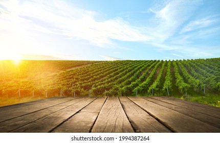 Brown wood table in autumn vineyard scenery against sunset sky with blank copy space on table for product display mockup. Winery and wine tasting concept. - Shutterstock ID 1994387264