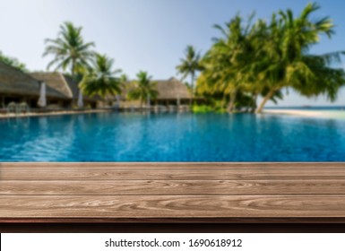 Brown wood table in summer seaside resort with empty copy space on the table for product display mockup. Travel vacation concept.
