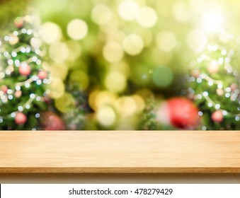 Brown Wood Table Top With Abstract Blur Christmas Tree Background With Bokeh Light,Holiday Backdrop,Mock Up For Display Or Montage Of Product.