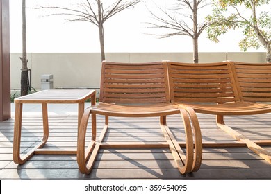 Brown Wooden Beach Chairs And Side Table On Wood Floor Near Swimming Pool