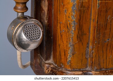 Brown Wooden Case Of An Old Telephone Set With Receiver. Old Shabby Telephone Close Up On A Gray Background. Retro Phone With Vintage Round Handset For Telecommunication And Conversation.