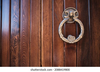 Brown wooden door with brass knocker