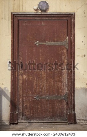 brown wooden enterance door. Old fashioned front door, all in dark brown colors. Weathered door platband