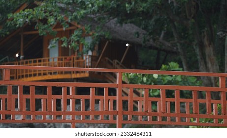 The brown wooden fence stands elegantly against the backdrop of a cottage - Powered by Shutterstock