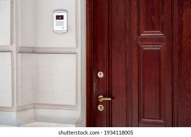 Brown Wooden Front Door Cracked Stone Facade Light Building Exterior With Intercom For Security With Video Camera And Microphone, Closeup Nobody.