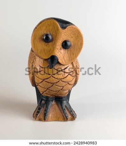 Brown wooden owl figurine carved from hardwood on a white background.