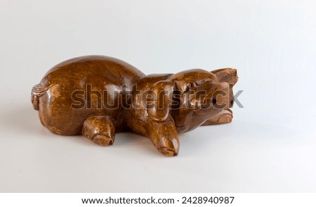 Brown wooden pig figure carved from hardwood on a white background.