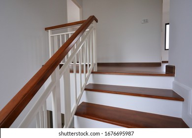 brown wooden stair with white steel balustrade and hardwood handrail banister in modern residential house