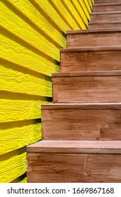 A brown wooden stair with yellow wooden wall shallow focus