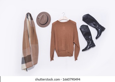 brown wool 
sweater on hanging with black leather boots and hat, scarf 


