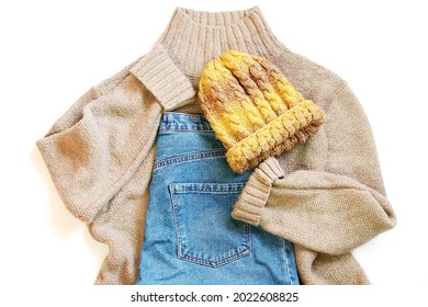 Brown Woolen Sweater, Blue Jeans And Yellow Knitted Hat. Fall And Winter Fashion Outfit Flat Lay Photography