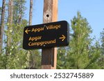 Brown and yellow arrow sign for Apgar village and Apgar campground at Glacier National Park. Find your way.