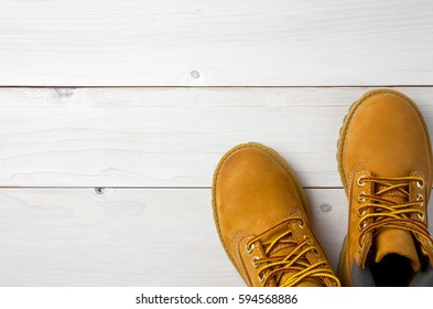 brown or yellow boots shoes for foot and adventure travel place on vintage white floor or table with copy space - Shutterstock ID 594568886
