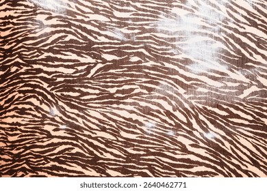 Brown zebra print pattern background with flowing stripes on cream fabric surface. Wild animal print texture perfect for fashion and neutral decorative design projects.
